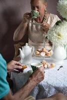 Tee brechen im das Englisch Stil, immer noch Leben mit Blumen und Donuts im das Morgen foto
