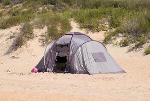 Tourist Zelt auf das Sand. Parkplatz von Touristen auf das sandig Strand foto