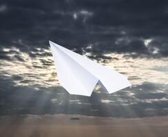 Weiß Papier Flugzeug im ein Blau Himmel mit Wolken. das Botschaft Symbol im das Bote foto