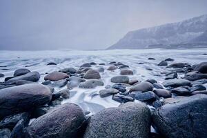Wellen von norwegisch Meer wogend auf Stein Felsen. lange Exposition foto