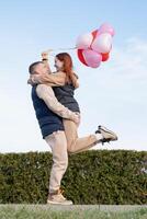 heiter romantisch Paar Dating draußen mit Luftballons foto