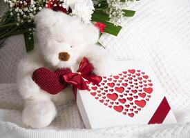Valentinstag Tag Geschenk, Teddy Bär mit ein Herz, ein Box von Pralinen und ein Strauß foto
