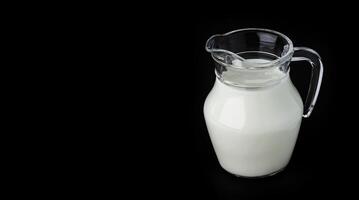 Glas Krug von Milch auf schwarz Hintergrund mit Kopieren Raum foto