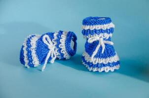 Blau gestrickt Booties auf ein Blau Hintergrund foto