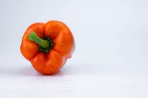 frisch Orange Glocke Pfeffer mit Wasser Tropfen isoliert auf Weiß Hintergrund. foto