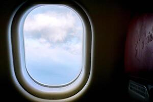 Nahansicht Fenster im das Flugzeug mit Blau und höher von Landschaft Aussicht Hintergrund. foto