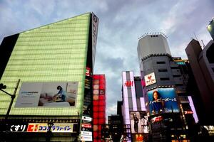 Osaka Stadt, Japan, 2023 - - Landschaft Aussicht von japanisch Einkaufen Einkaufszentrum mit Werbung Neon- Zeichen beim Schienbein sai ba schi Bereich auf Winter und früh Abend Himmel Hintergrund. foto