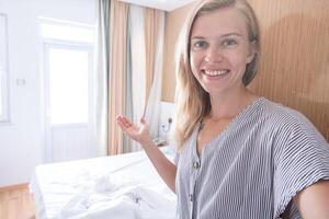 glücklich Frau zeigen ihr Hotel Zimmer nehmen Selfie foto