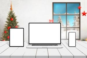 Laptop-, Tablet- und Smartphone-Modell auf weißem Schreibtisch mit Weihnachtsschmuck im Hintergrund. Responsive Design-Präsentationsvorlage