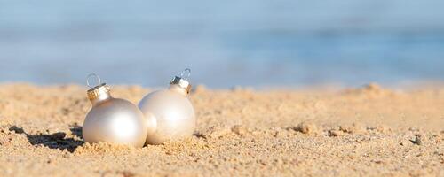 Weihnachten Dekorationen Flitter Ball auf sandig Strand mit Meer Hintergrund foto