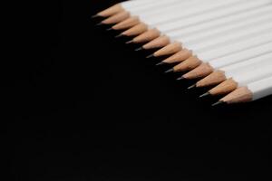 Weiß Bleistifte auf schwarz Hintergrund mit Kopieren Raum. foto
