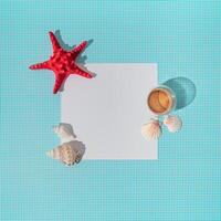 kreativ Sommer- Layout gemacht mit Tasse von Kaffee, rot Seestern, Meer Muscheln und Papier Karte Hinweis Kopieren Raum auf Weiß und Blau Hintergrund. minimal Sommer- Kaffee Konzept. eben legen. foto