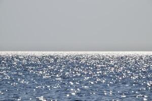 Meer Linie von das Horizont. Meer und Himmel. das Wellen und Blendung von das Sonne sind reflektiert von das Wellen von das Meer. Meereslandschaft. foto