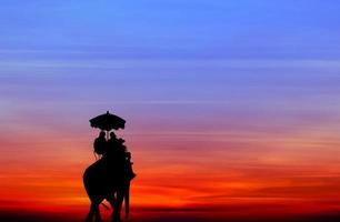 Silhouette Elefant mit Touristen bei Sonnenuntergang foto