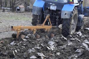 Traktor Pflügen das Garten. Pflügen das Boden im das Garten foto