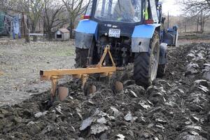 Traktor Pflügen das Garten. Pflügen das Boden im das Garten foto