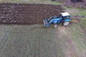 Traktor Pflügen das Garten. Pflügen das Boden im das Garten foto