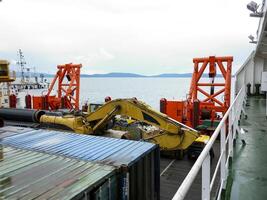 das Deck legen Lastkahn. Rohre und Heben Kräne auf das Schiff. Ausrüstung zum Verlegung ein Pipeline auf das Meeresboden foto