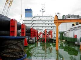 das Deck legen Lastkahn. Rohre und Heben Kräne auf das Schiff. Ausrüstung zum Verlegung ein Pipeline auf das Meeresboden foto