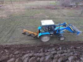 Traktor Pflügen das Garten. Pflügen das Boden im das Garten foto