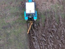 Traktor Pflügen das Garten. Pflügen das Boden im das Garten foto