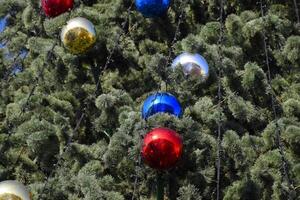 Dekorationen Neu Jahr Baum. Lametta und Spielzeuge, Bälle und andere Dekorationen auf das Weihnachten Weihnachten Baum Stehen im das öffnen Luft. foto