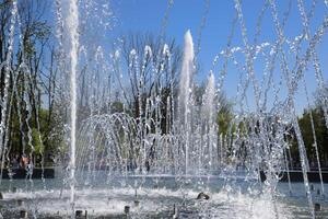 Stadt Brunnen im das Stadt von krasnodar. Menschen sind Gehen durch das Brunnen. Wasser Spritzer. foto