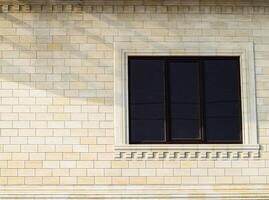 Hintergrund von Gelb Backstein und Fenster. Mauer von Gelb Ziegel mit ein Plastik Fenster. das Textur von das Mauer foto