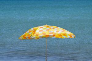 Strand Regenschirm von das Sonne auf das Strand. schwarz Meer foto