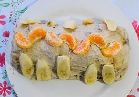 Kuchen mit Banane und Mandarinen, bestreut mit Schokolade. foto