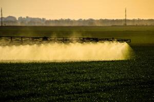 Jets von Flüssigkeit Dünger von das Traktor Spritzgerät. foto