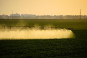 Jets von Flüssigkeit Dünger von das Traktor Spritzgerät. foto