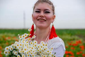 jung Mädchen mit ein Strauß von Gänseblümchen im Feld. Gänseblümchen auf ein Mohn Feld. foto