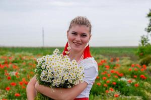 jung Mädchen mit ein Strauß von Gänseblümchen im Feld. Gänseblümchen auf ein Mohn Feld. foto