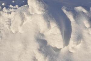 Klumpen von Schnee im Winter. Schnee und Licht während das Tag. Schneeverwehungen. foto