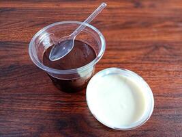 Schokolade Pudding und Milch im ein Tasse auf ein hölzern Tabelle foto