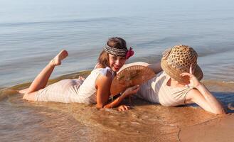 zwei jung Frauen im retro Badeanzüge durch das Meer foto