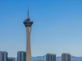 modern Stratosphäre Turm dominiert las Vegas Horizont inmitten Blau Himmel und Hochhäuser foto