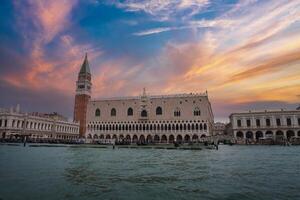 szenisch Venedig Stadtbild mit Boote und historisch die Architektur angesehen von das Wasser beim Sonnenuntergang foto