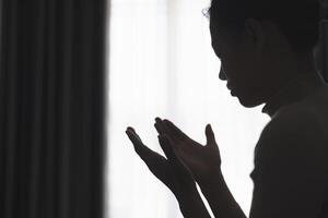 Silhouette von ein Person beten zu Gott und heilig Dinge, religiös Konzept, Vertrauen und Glauben, religiös. foto