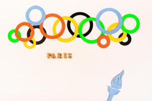 Olympia, Paris, Frankreich, Sommer, 2024. mehrfarbig Ringe, Text und Flamme auf ein Licht Hintergrund foto