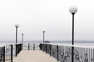 nebelig Seebrücke mit Laternen foto