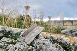 Scherbe von uralt Keramik auf ein Stein gegen ein Hintergrund von verschwommen uralt Ruinen foto