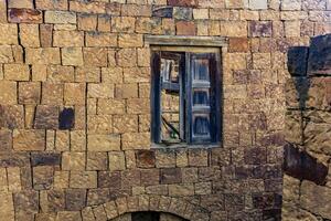 uralt hölzern Fenster mit Fensterläden im das Ruinen von das verlassen Dorf von gamsutl, Dagestan foto