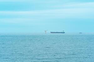 nebelig Seelandschaft mit ein Tanker in der Nähe von ein Öl Terminal gelegen weit aus zu Meer, oben Aussicht foto