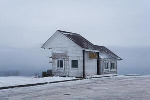 alt hölzern Gebäude von ein Transport Cafe auf ein Berg bestehen im ein schneebedeckt Winter Landschaft im Dauerwelle krai, Russland foto