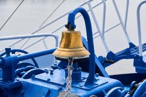 Messing- Glocke auf das Vordeck von ein Schiff im wolkig Licht foto