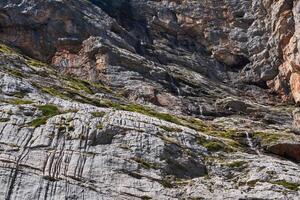 schier Felsen Mauer mit ein klein Wasserfall fließend Nieder es foto