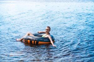 Teen Mädchen Schwimmen mit ein schwimmen Tube foto