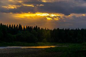 Sommer- Sonnenuntergang Über das Norden Flussmit bewaldet Banken foto